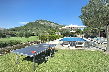 A ping pong table sits in front of a swimming pool