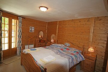 A bedroom with a large bed and a dresser