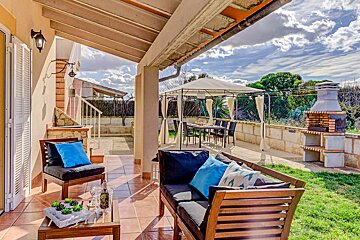 A patio with a couch and chairs with blue pillows