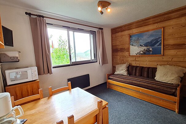 A living room with a couch a table and a microwave