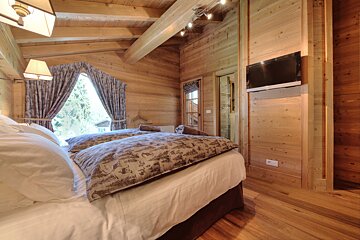 A bedroom with two beds and a flat screen tv