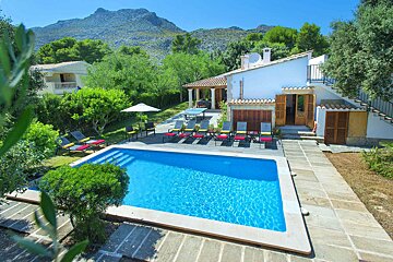 A house with a large pool in front of it