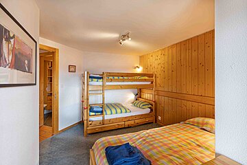 A bedroom with bunk beds and a painting on the wall
