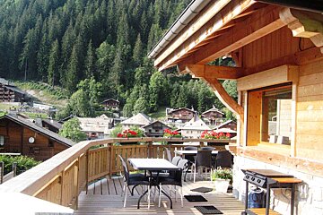 A wooden deck with a table and chairs on it