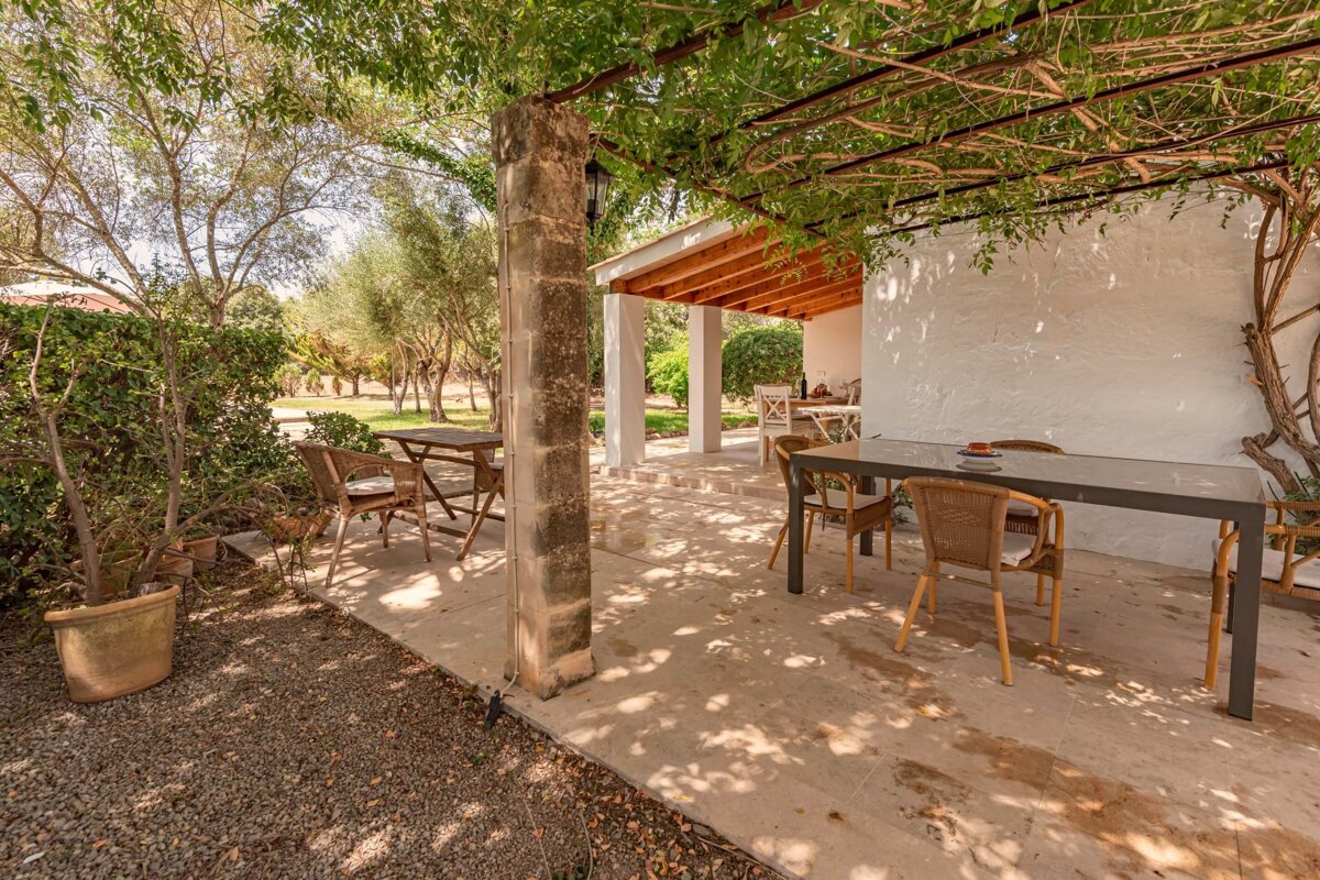 A patio with a table and chairs under a pergola