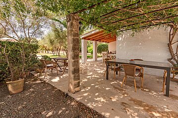 A patio with a table and chairs under a pergola
