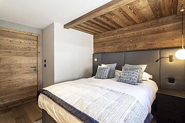 A bedroom with a bed and a wooden door