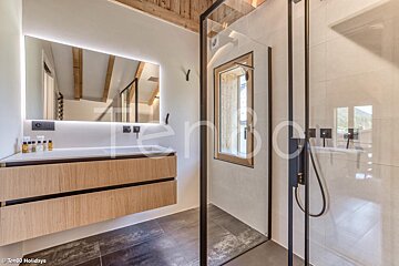 A bathroom with a large mirror and a walk in shower