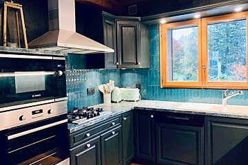 A kitchen with black cabinets and a bosch oven