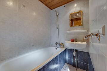 A bathroom with a sink and a bathtub and a mirror