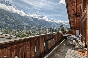 A balcony with a view of the mountains and the word ten80 on it