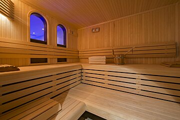 A wooden sauna with a bucket and towels on the benches
