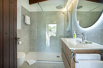 A bathroom with a walk in shower and a sink