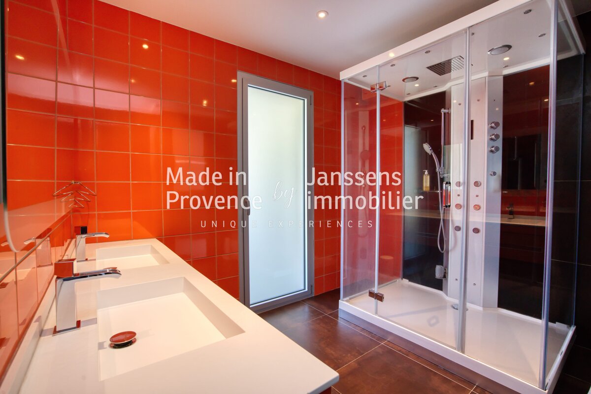 A bathroom with two sinks and a shower that says made in janssens provence immobilier