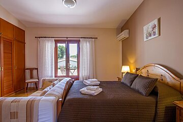 A bedroom with two beds and a picture on the wall