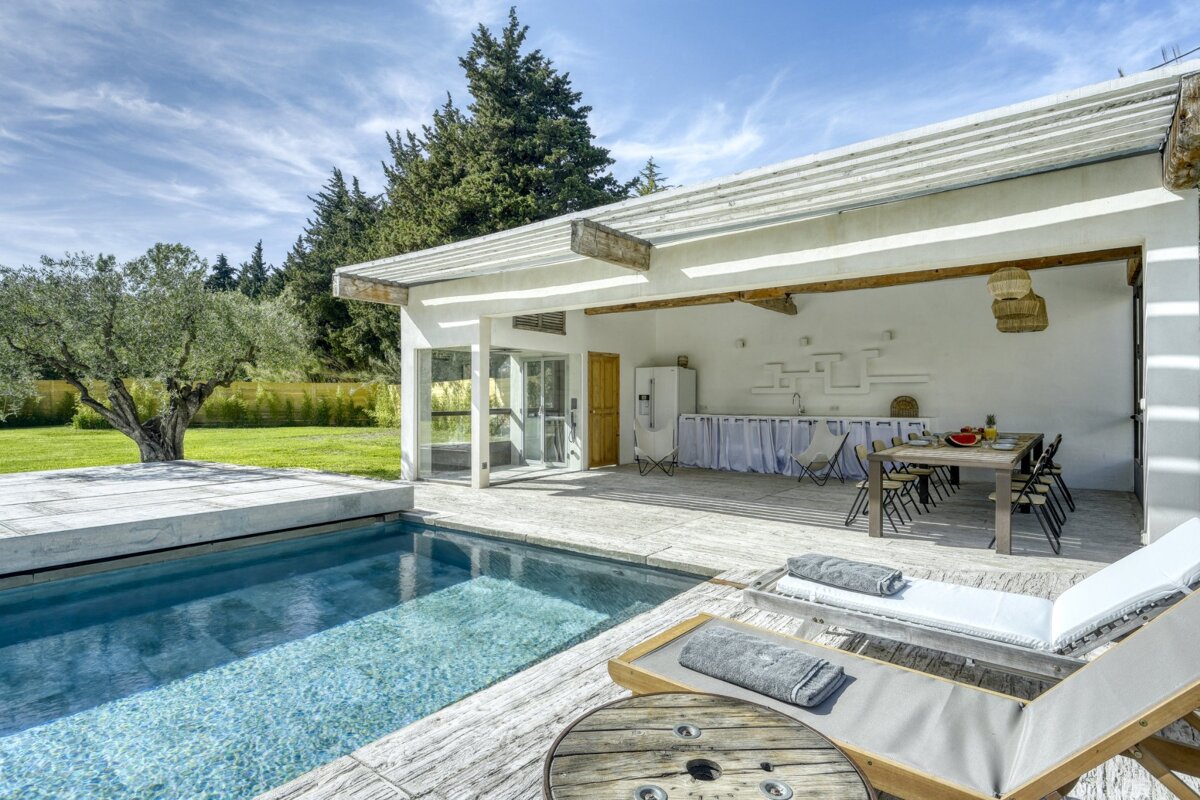 A house with a swimming pool and a table and chairs