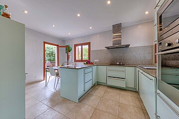 A kitchen with blue cabinets and a stainless steel oven