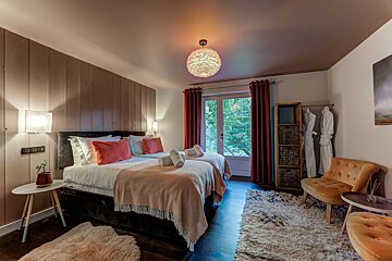 A bedroom with two beds a chair and a rug