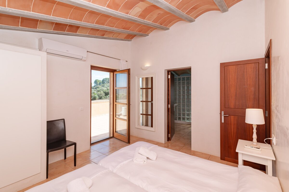 A bedroom with a white bed and a wooden door