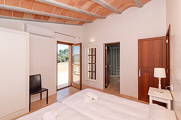 A bedroom with a white bed and a wooden door