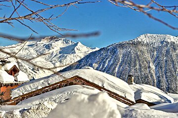 A snow covered roof with mountains in the background