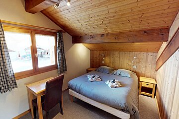 A bedroom with a king size bed and a desk