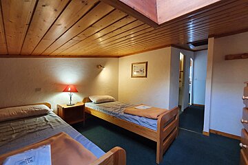 A bedroom with two twin beds and a lamp
