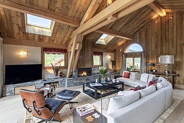 A living room with a vaulted ceiling and a fireplace