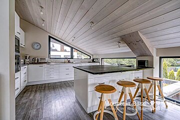 A kitchen with stools and a clock that says mountain base