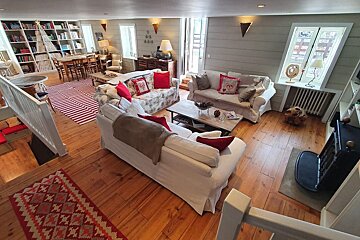 A living room with a white couch and red pillows