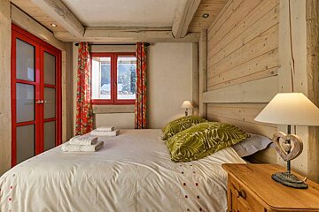 A bedroom with a bed a lamp and a window