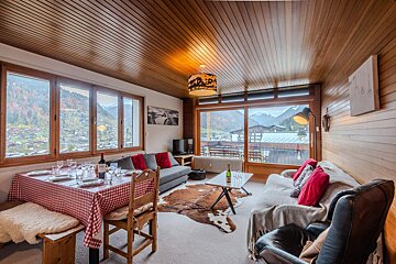 A living room with a couch a table and a view of the mountains