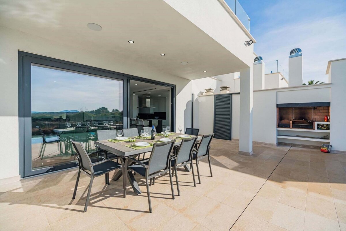 A patio with a table and chairs and a grill