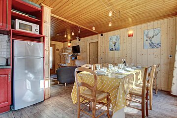A kitchen with a table and chairs and a refrigerator