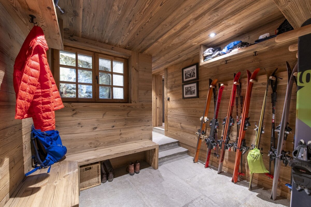 A wooden room with skis and snowboards hanging on the wall