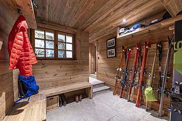 A wooden room with skis and snowboards hanging on the wall