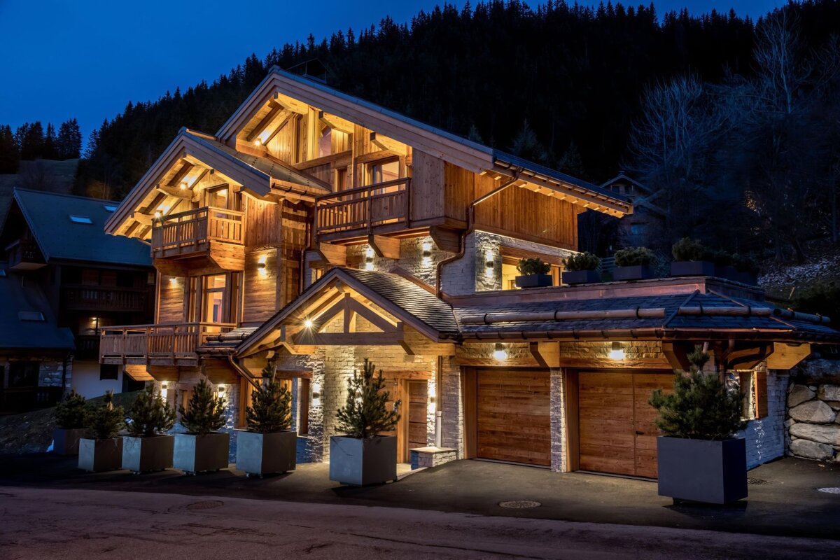A large wooden house is lit up at night