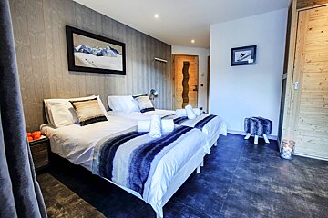 A bedroom with two beds and a picture on the wall