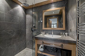 A bathroom with a sink a mirror and a walk in shower