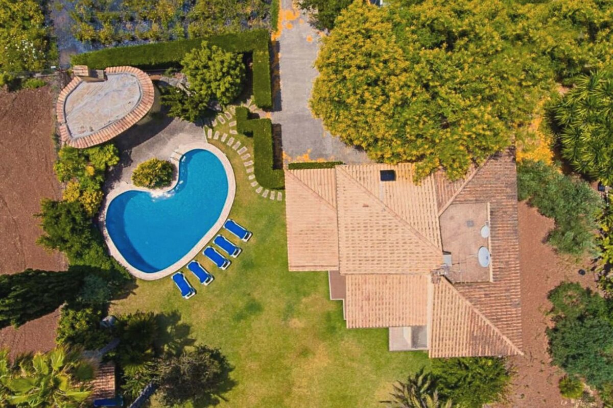 An aerial view of a house with a large swimming pool