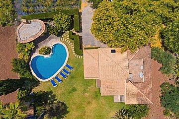 An aerial view of a house with a large swimming pool