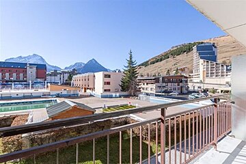 A balcony overlooking a city with mountains in the background