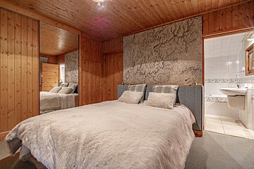 A bedroom with a large bed and a bathroom