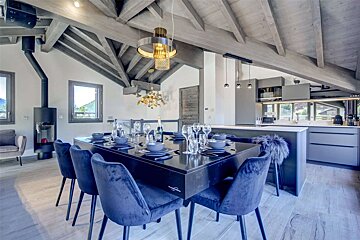 A dining room with a black table and chairs