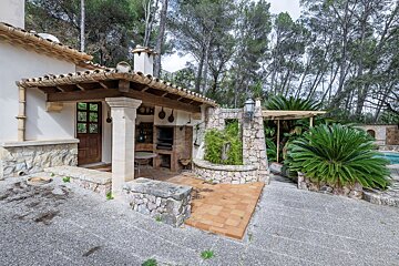 A house with a covered patio and a barbecue area