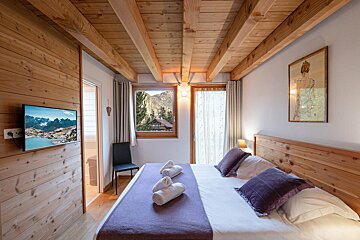 A bedroom with a large bed and a flat screen tv