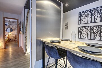 A dining room table with plates and utensils on it