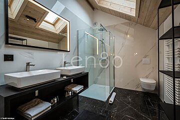 A bathroom with two sinks and a toilet and the word tengo on the wall