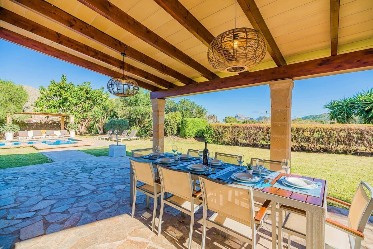 A patio with a table and chairs and a bottle of wine
