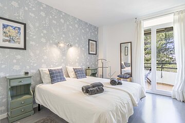 A bedroom with a bed a nightstand and a mirror